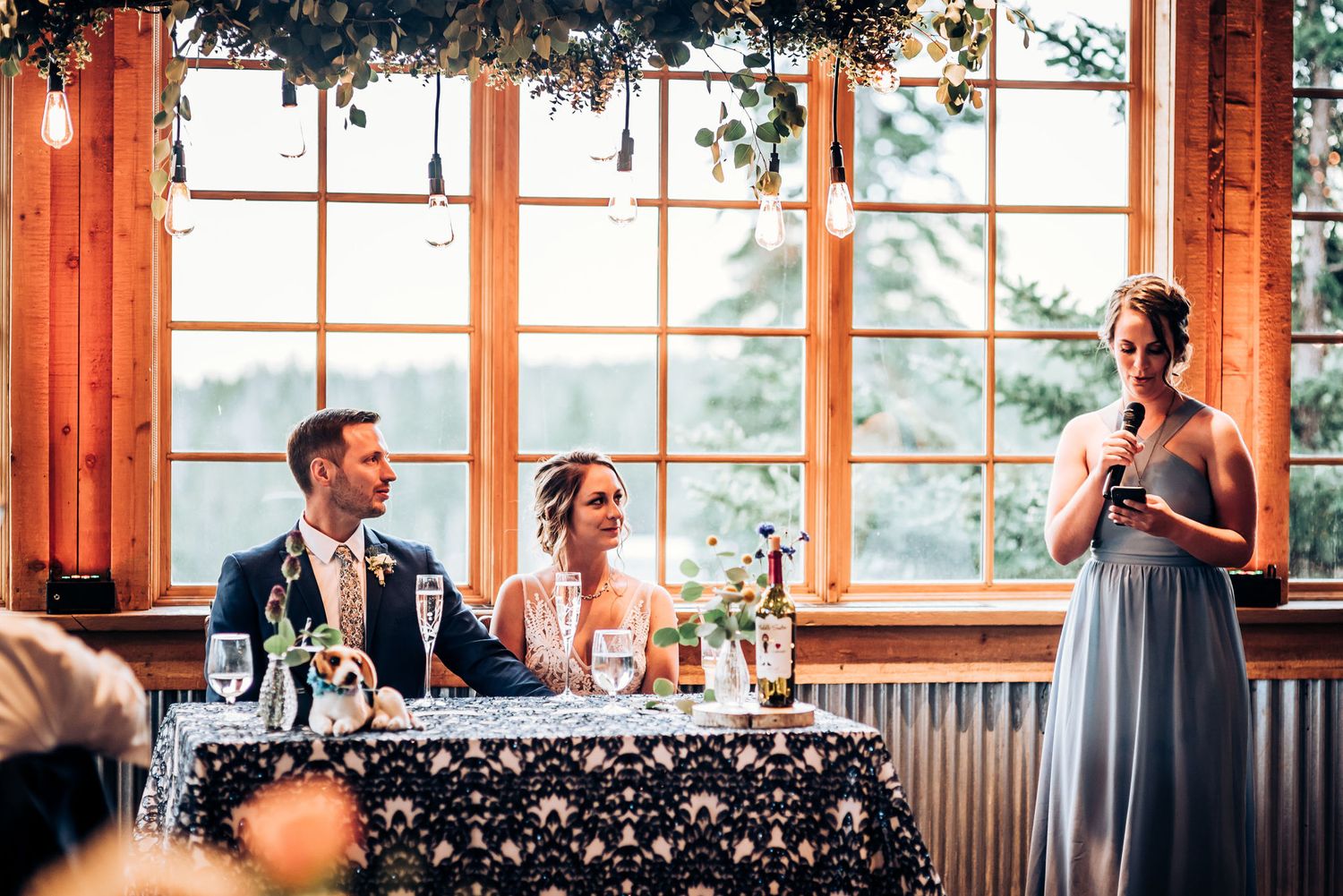 Wedding reception venue with large windows and elegant greenery decorations.