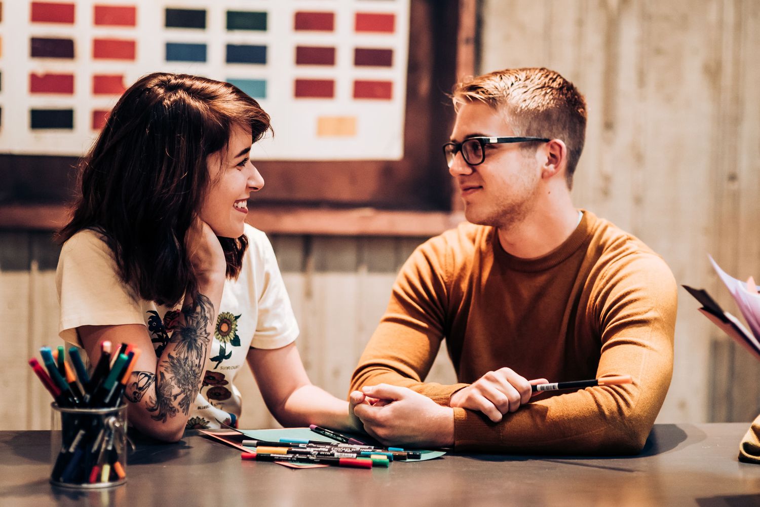 Two creatives share a conversation while working on an art project together.