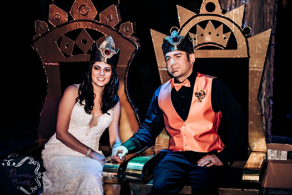 Wedding couple seated on decorative thrones at their reception venue.
