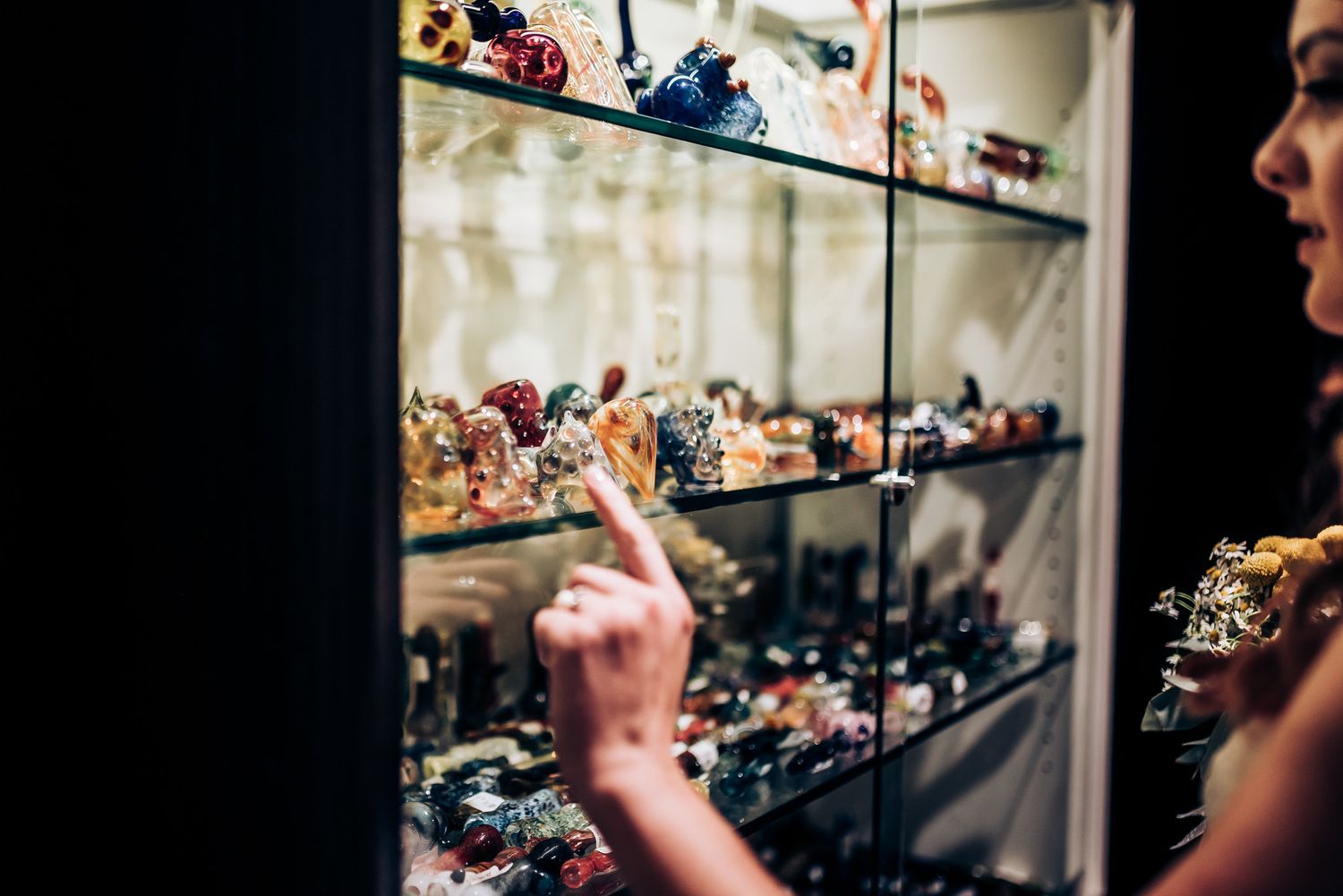 A display case filled with collectible figurines being viewed during a wedding.