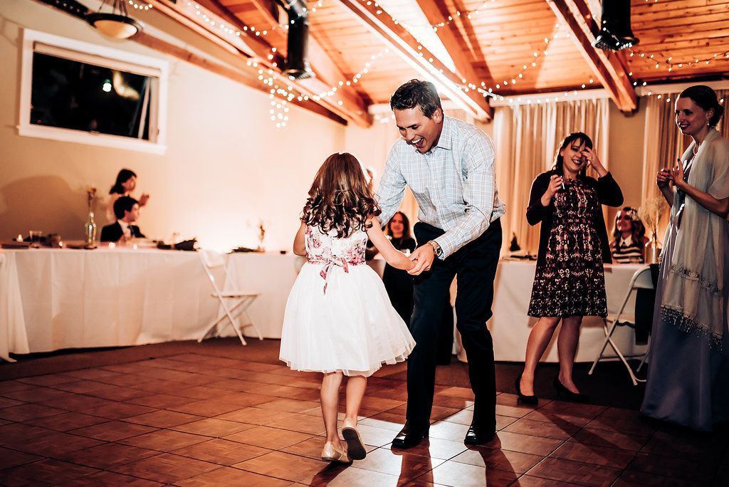 Sweet dance moment between adult and young child at wedding reception.