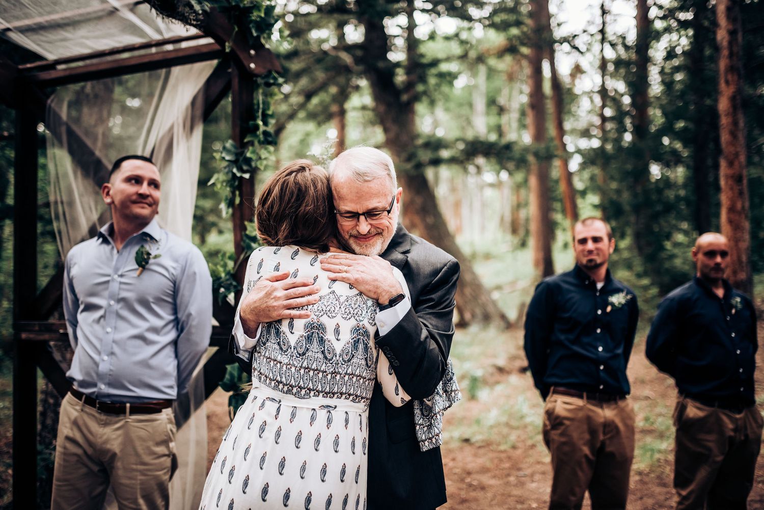 An emotional moment captured during an outdoor forest wedding ceremony.