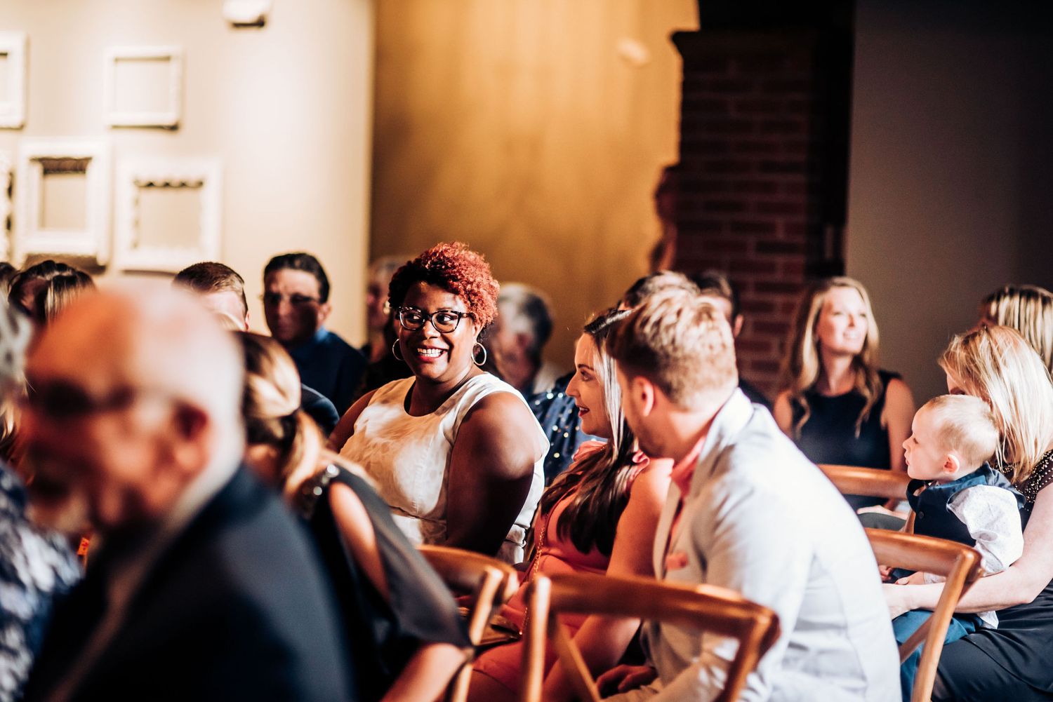 Wedding guests enjoying the celebration in a warmly lit reception venue.