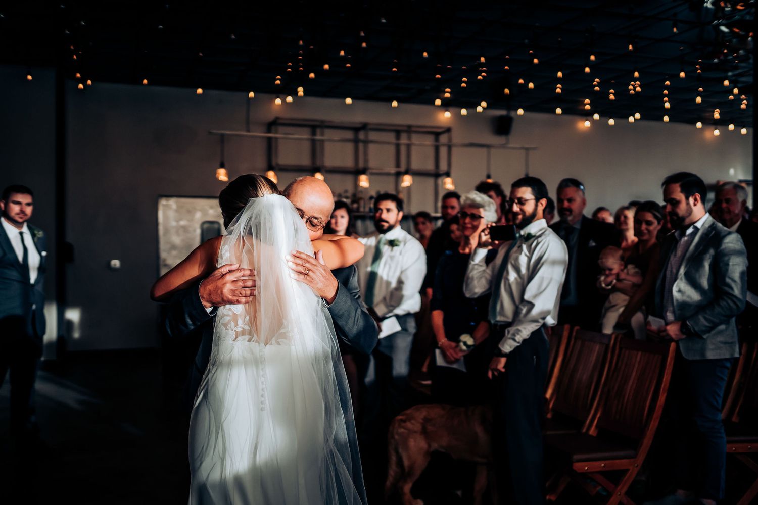 Wedding reception dance floor scene with guests celebrating under twinkling lights.