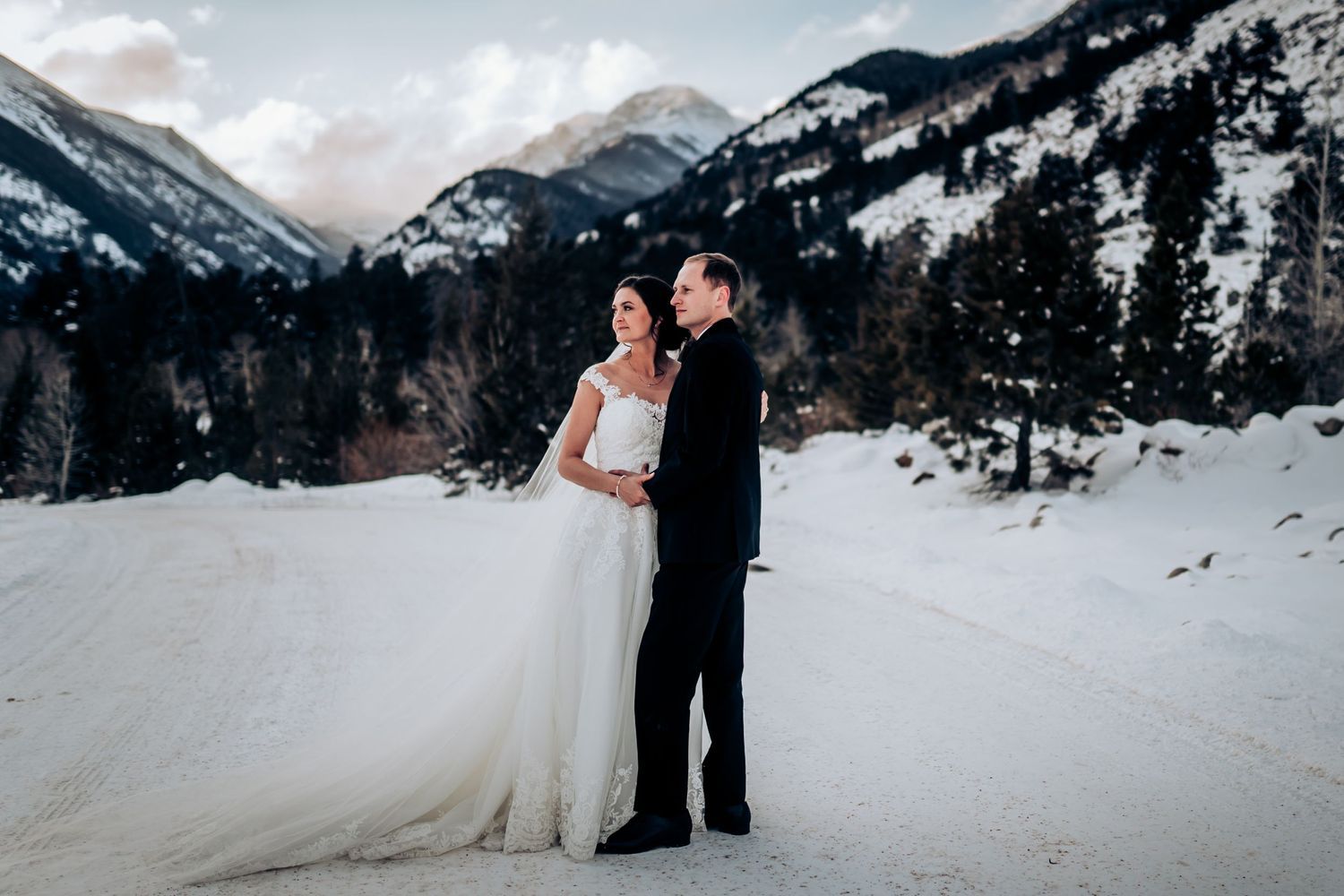 A snowy mountain landscape provides a dramatic backdrop for a winter wedding ceremony.