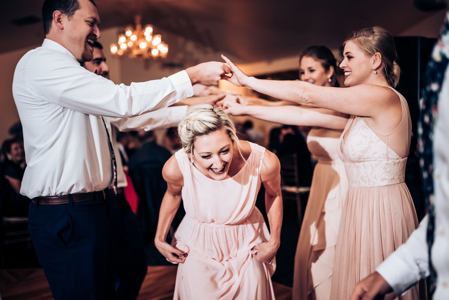 Dancers form a circle during an energetic wedding reception celebration.