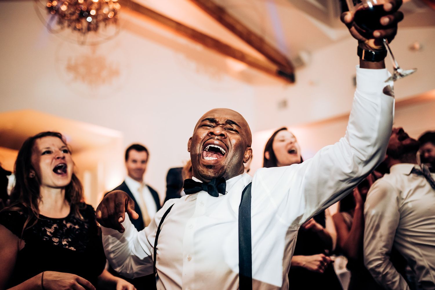 Guest celebrates with pure joy during lively wedding reception dance party.