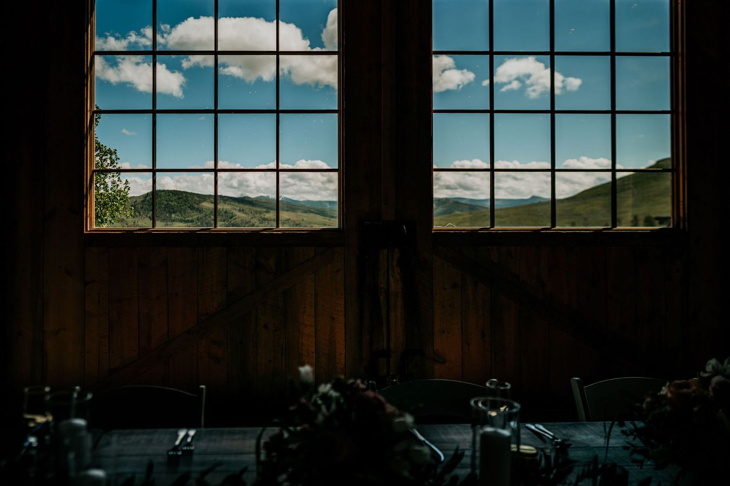 Mountain landscape viewed through large windows of rustic venue.