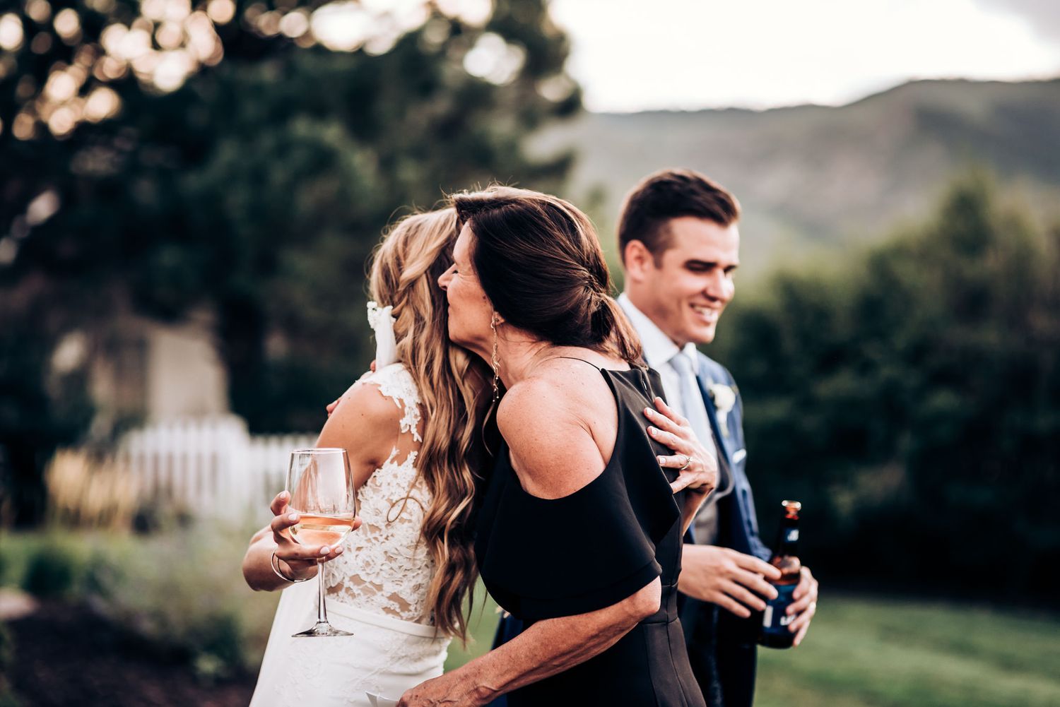 A celebratory moment between people at an outdoor wedding reception.