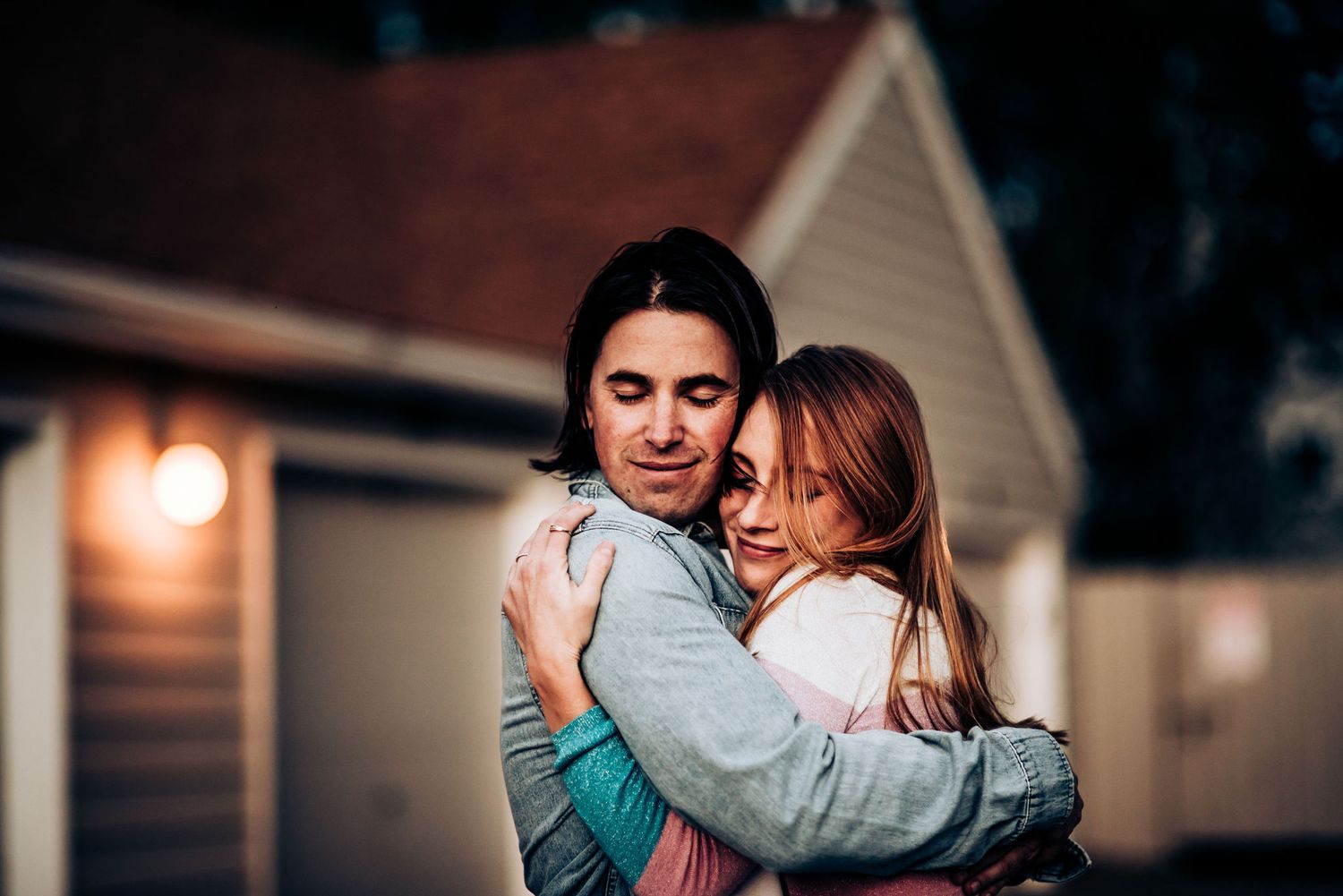 A couple shares an intimate embrace outside in the evening.