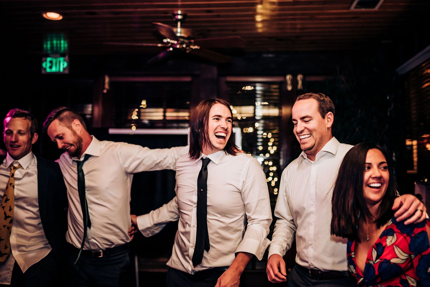 Group of guests laughing and celebrating together at an indoor party.