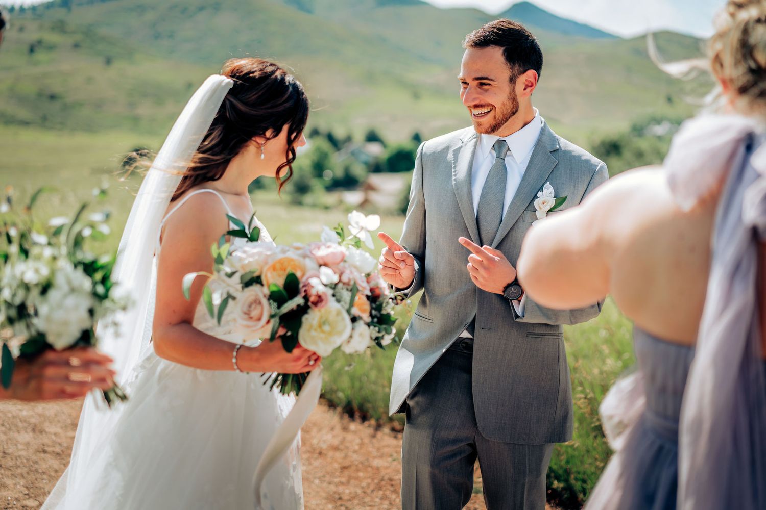 Outdoor wedding ceremony with couple exchanging vows against mountain backdrop.