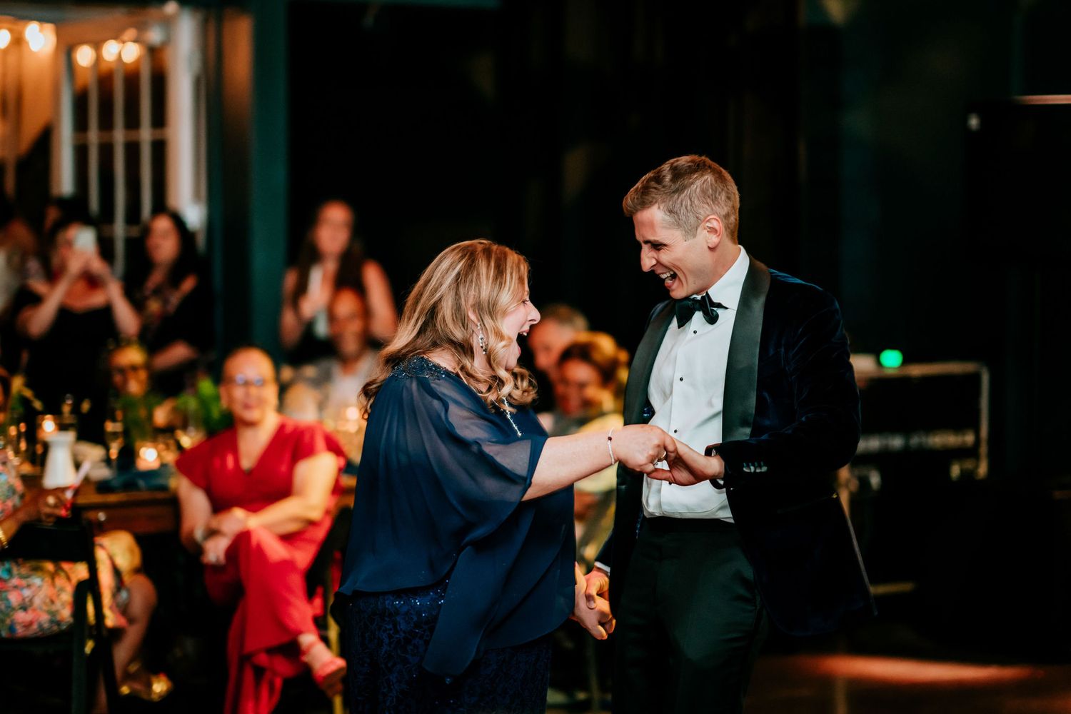 Couples dancing together during an elegant evening reception with warm lighting and festive atmosphere.