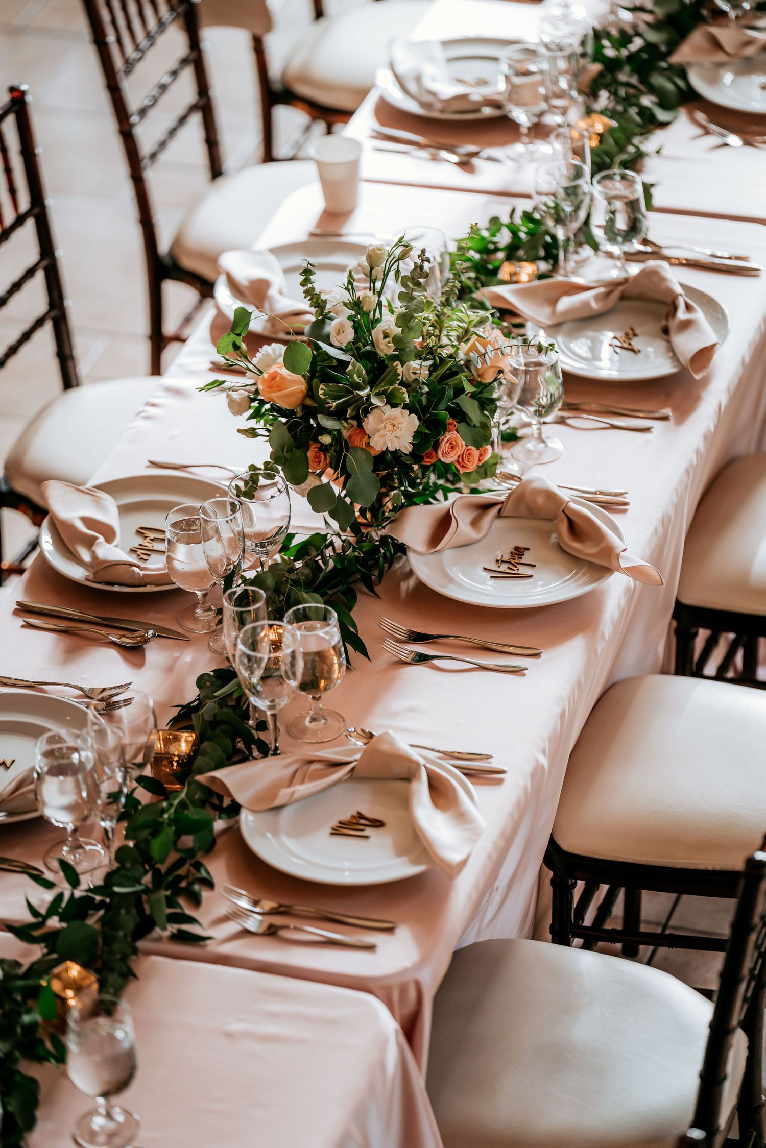 Elegant wedding table setting with floral centerpieces and white linens.