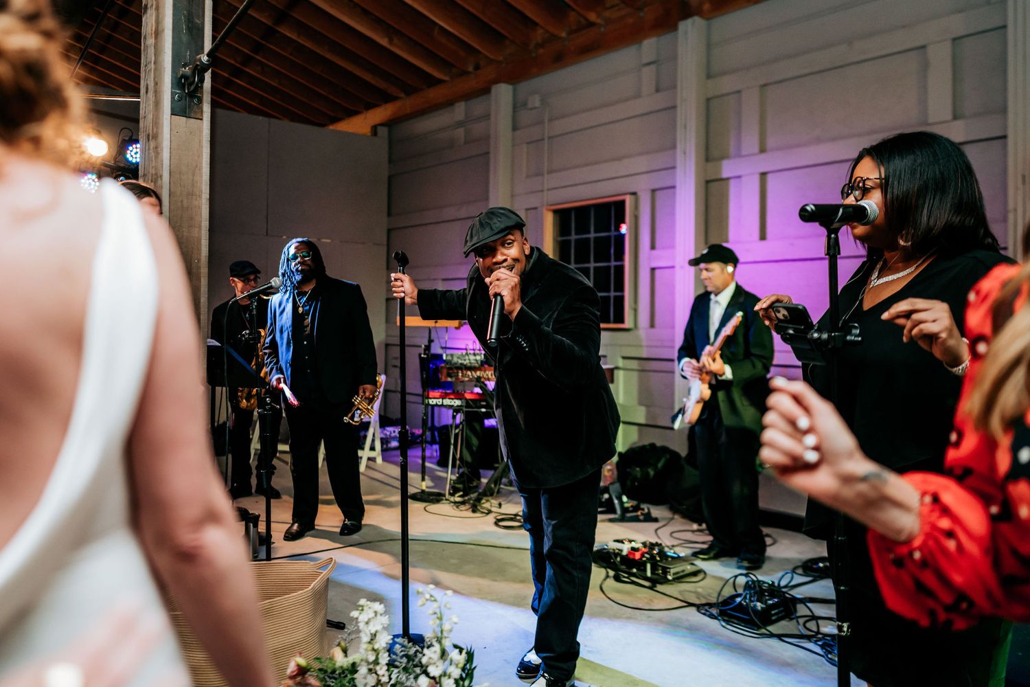 Live band performs for wedding celebration with instruments and equipment on stage.