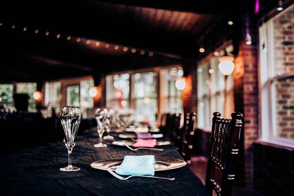 Elegant dining table setting with wine glasses and place settings in a dimly lit restaurant interior.