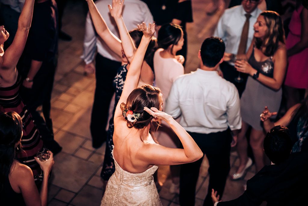 Celebration on dance floor with guests dancing under indoor lighting.