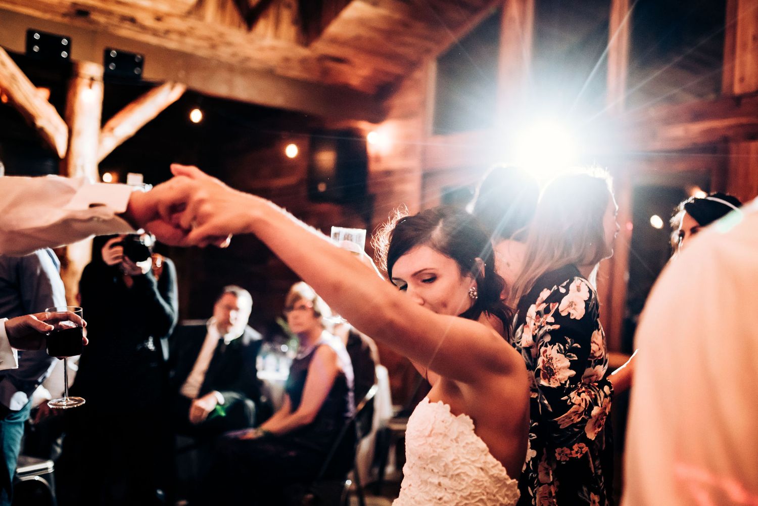 Wedding celebration dancing captured in dynamic motion at rustic wooden venue.