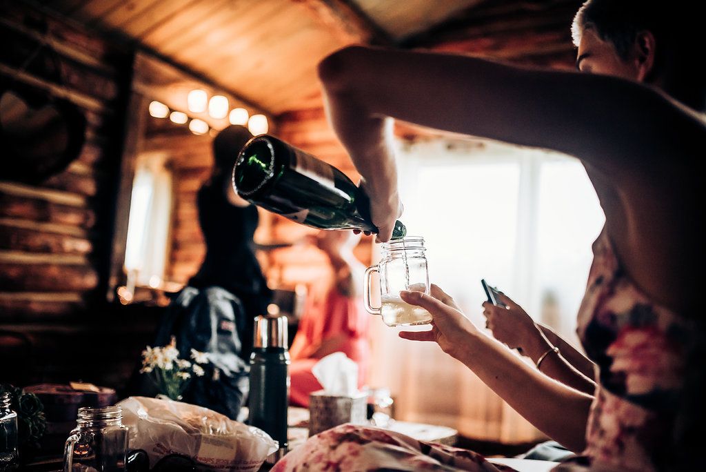 Champagne being poured into glasses in a rustic cabin setting with warm lighting.