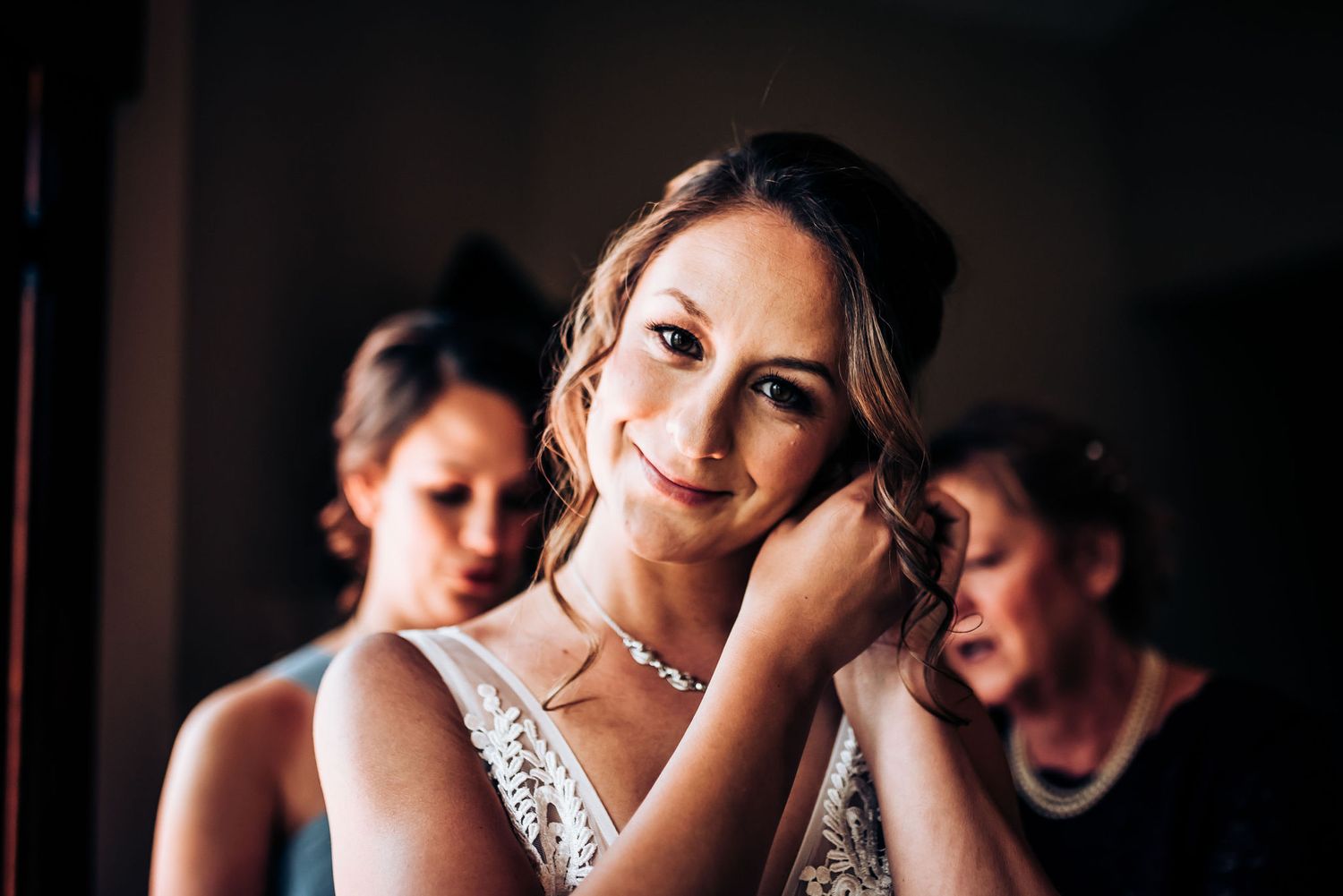 Candid moment during bridal preparations with elegant lace dress.