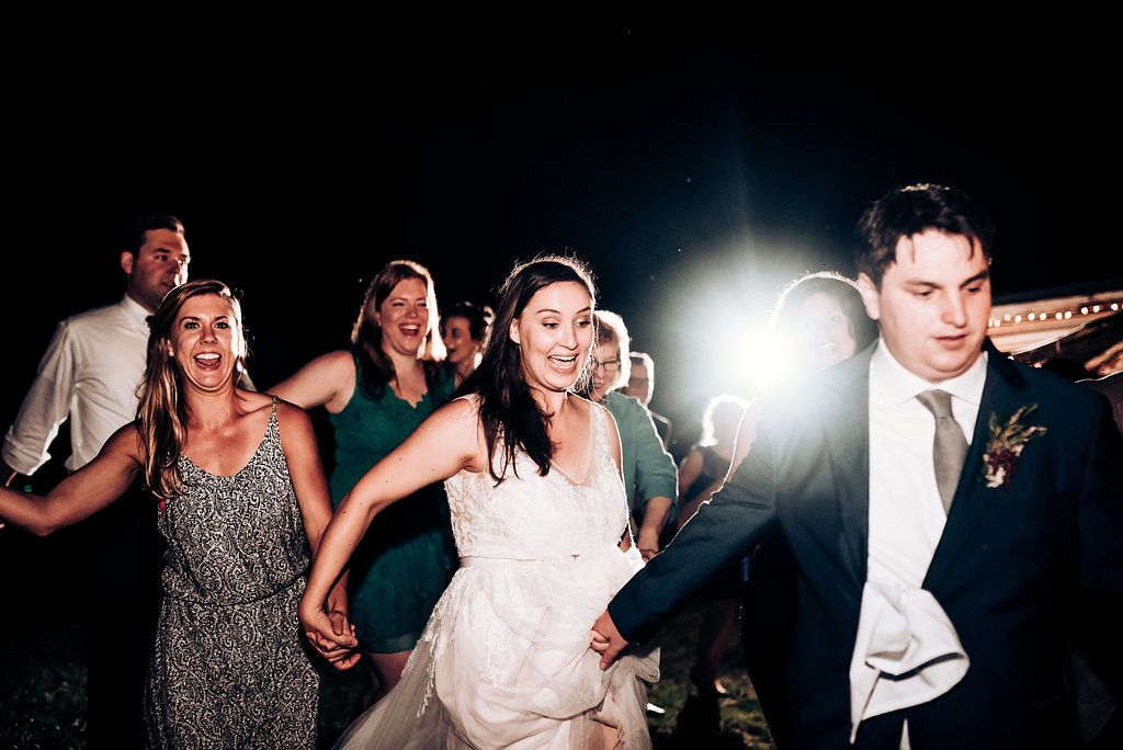 Energetic dancing and celebration on wedding reception dance floor.