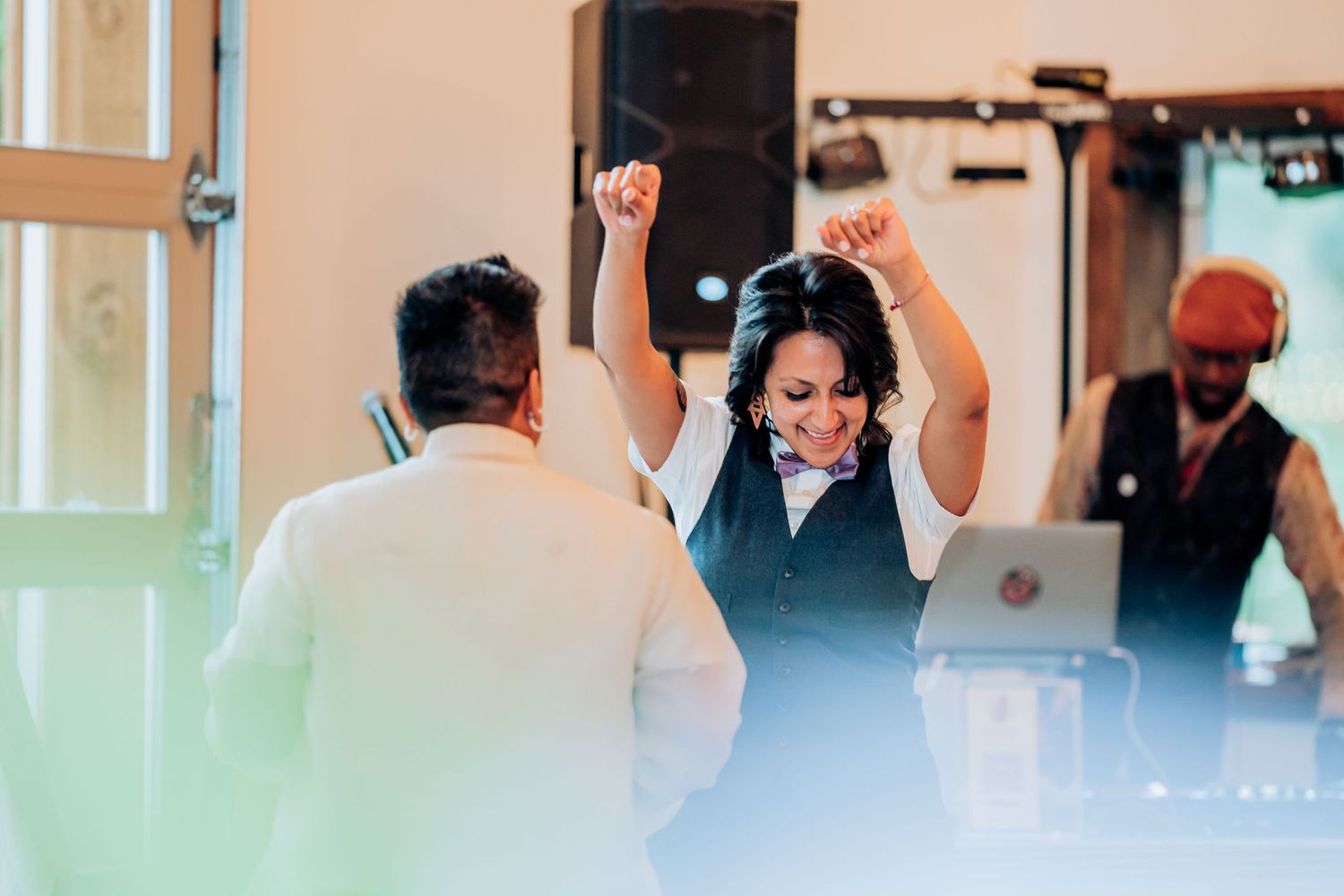 People dancing enthusiastically during a lively wedding reception celebration.