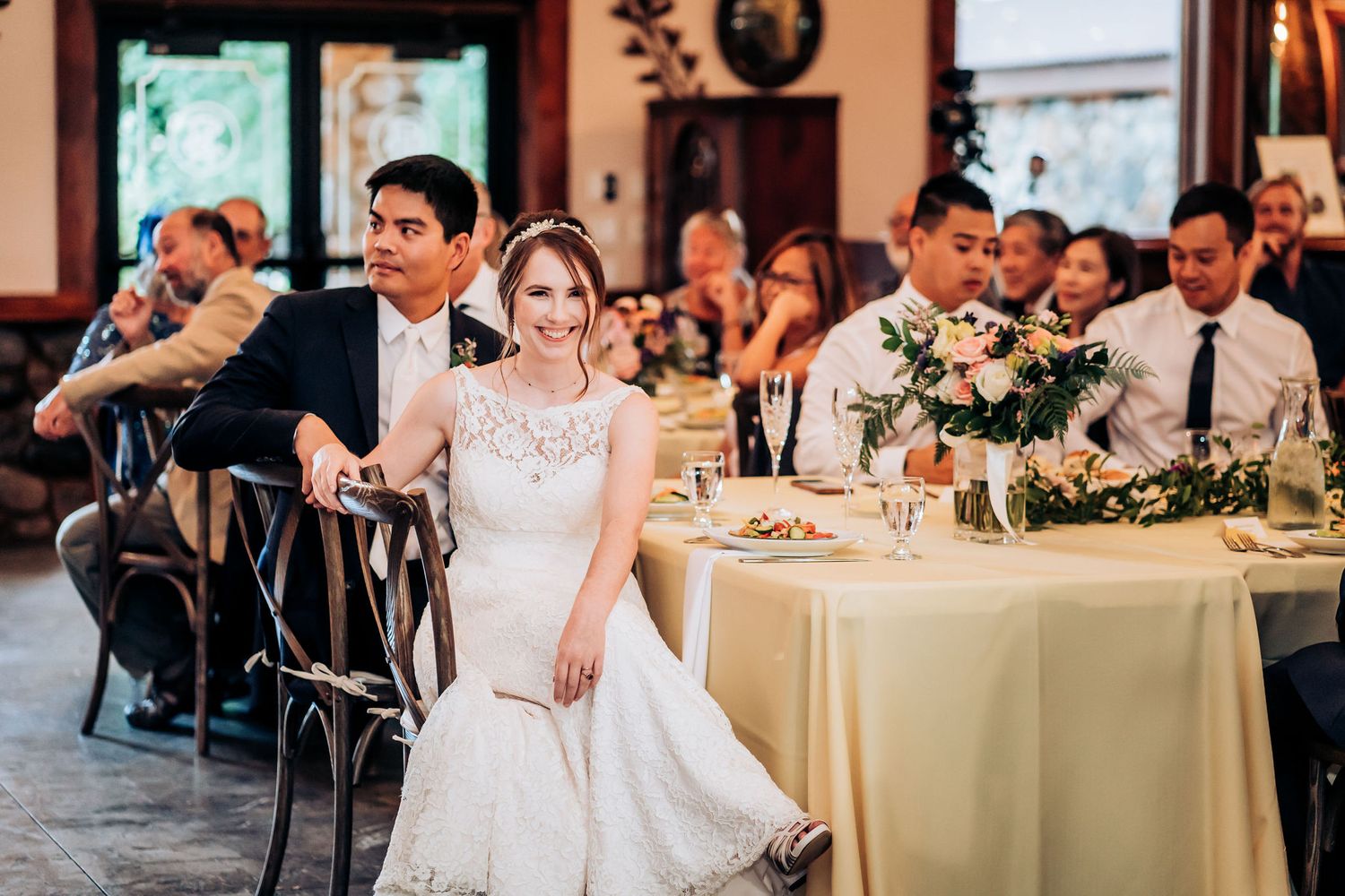 A reception scene with elegantly decorated tables and wedding party seated for dinner.
