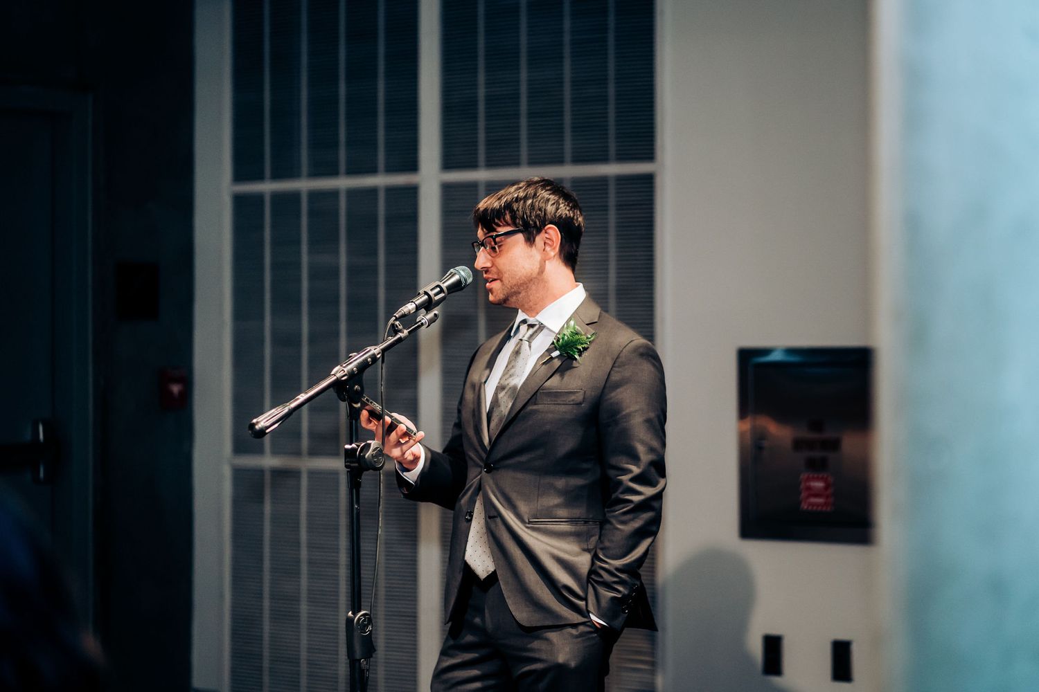Wedding speech being delivered at microphone stand during reception.