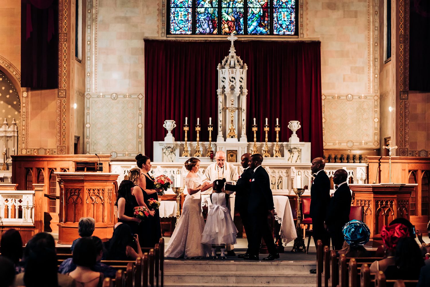 Wedding ceremony in progress at ornate church altar with traditional decorations.