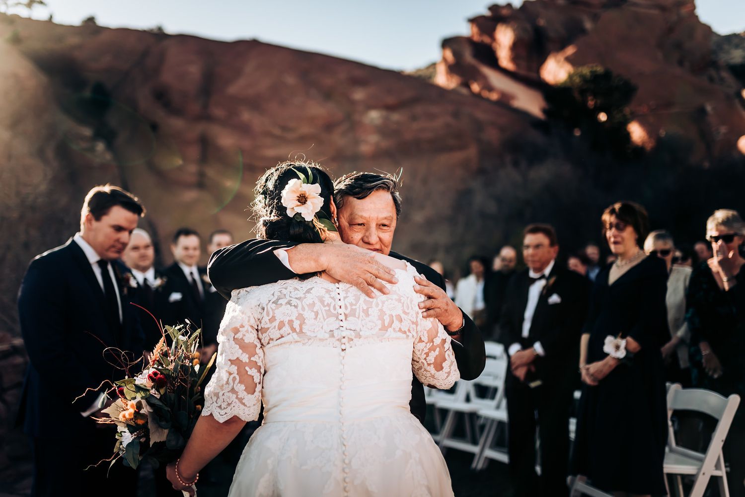 An emotional wedding moment captured during outdoor ceremony with mountain backdrop.