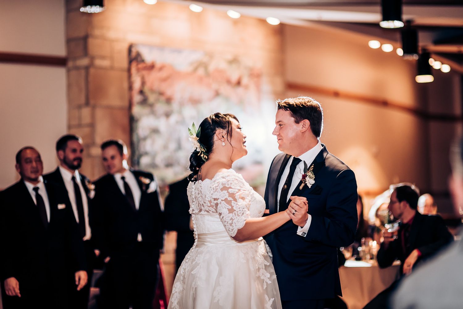 An elegant couple shares an intimate dance moment at their wedding reception.