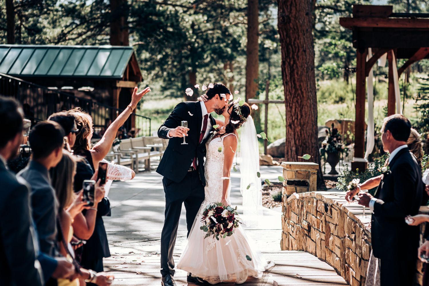 A celebratory moment during an outdoor wedding ceremony with guests cheering.