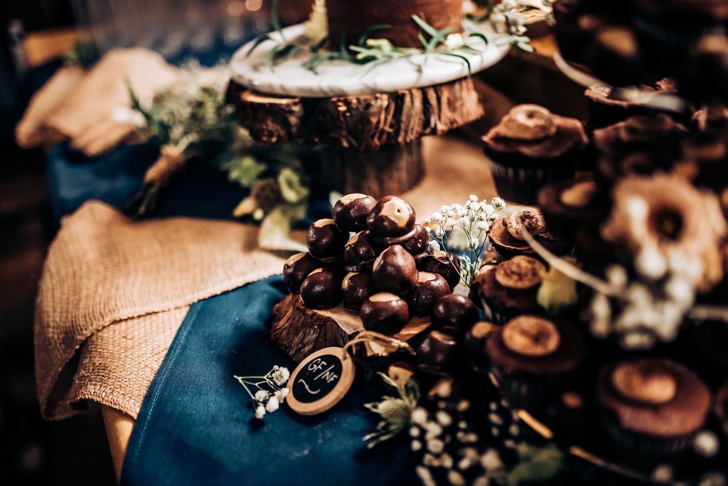 Wedding decor details with vintage keys and delicate floral arrangements on blue fabric.