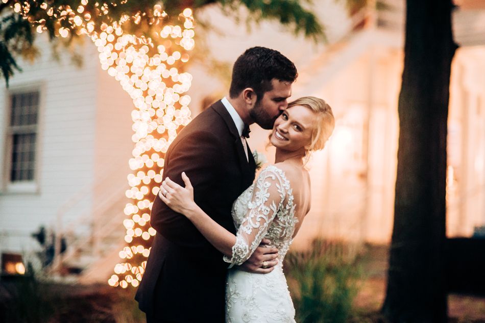 Evening wedding portrait with string lights creating a magical backdrop.
