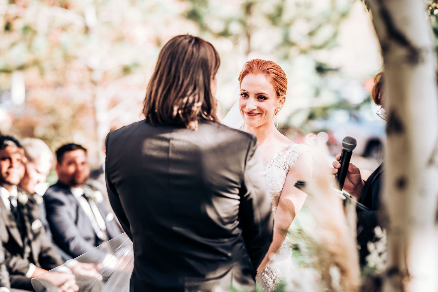 A touching exchange between wedding couple during their outdoor autumn ceremony.