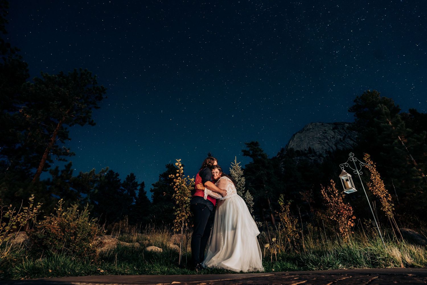 Silhouetted wedding couple against dramatic night sky.