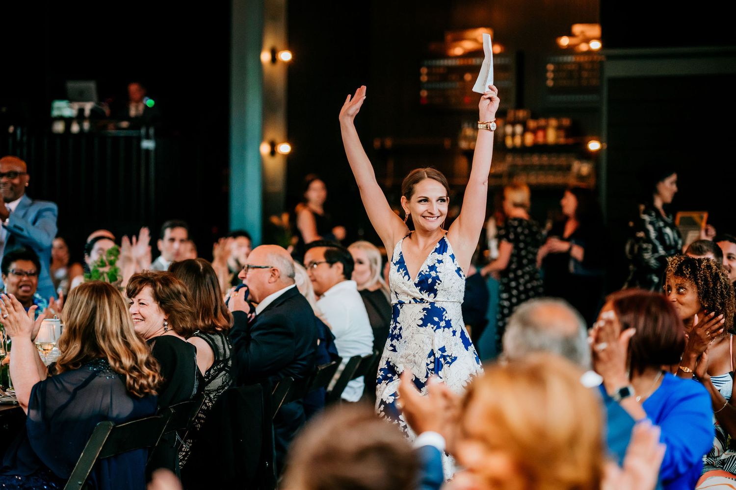 Joyful celebration with guests dancing and cheering at an indoor reception.