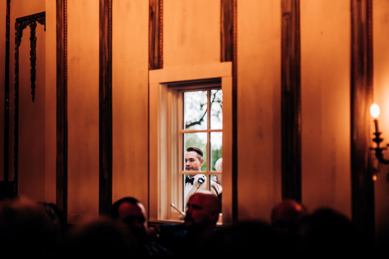 Illuminated doorway at a wedding venue with warm orange lighting and dramatic shadows.
