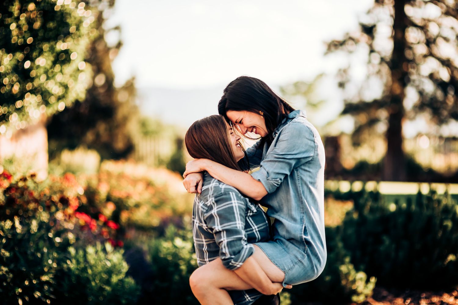 Couple sharing an intimate embrace in a garden setting during golden hour.