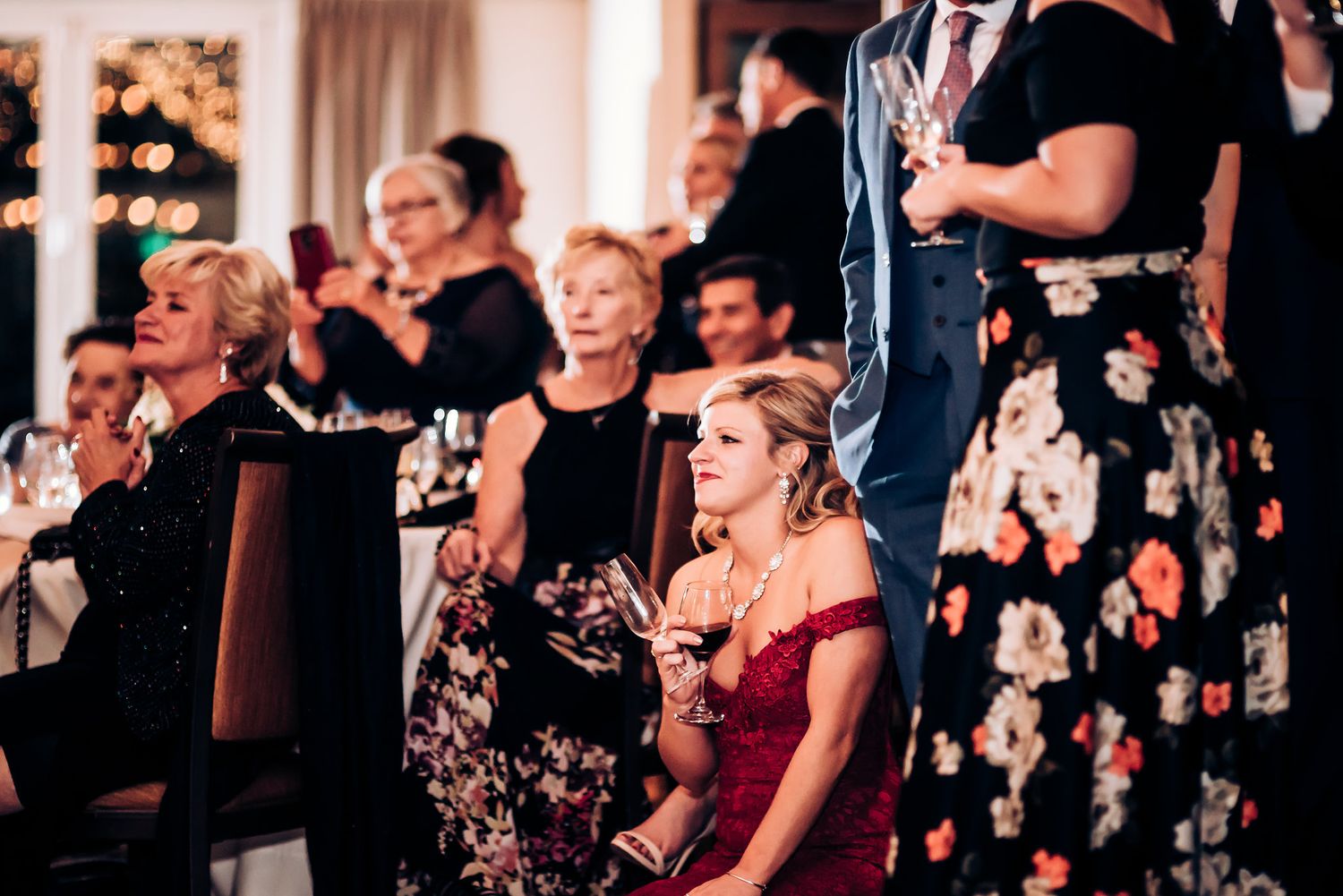 Wedding guests watch attentively during emotional reception moment.