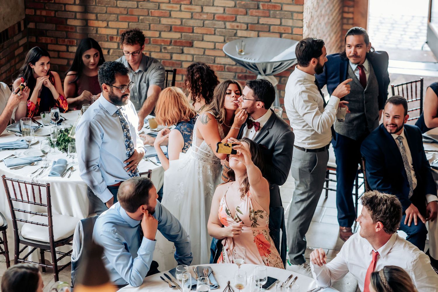 Candid moment of wedding guests socializing and laughing during the reception celebration.