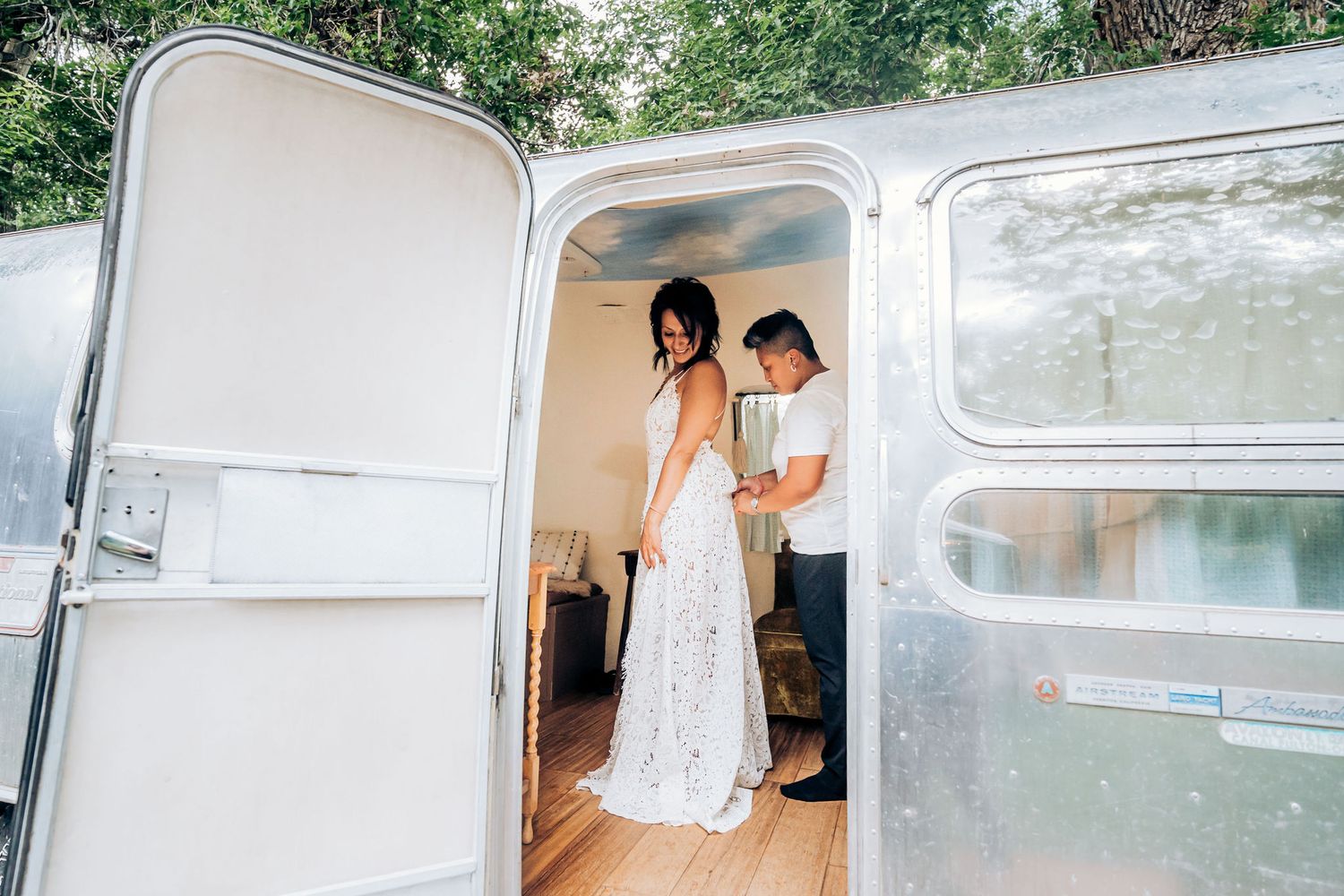 Couple sharing a tender moment in a vintage silver trailer.