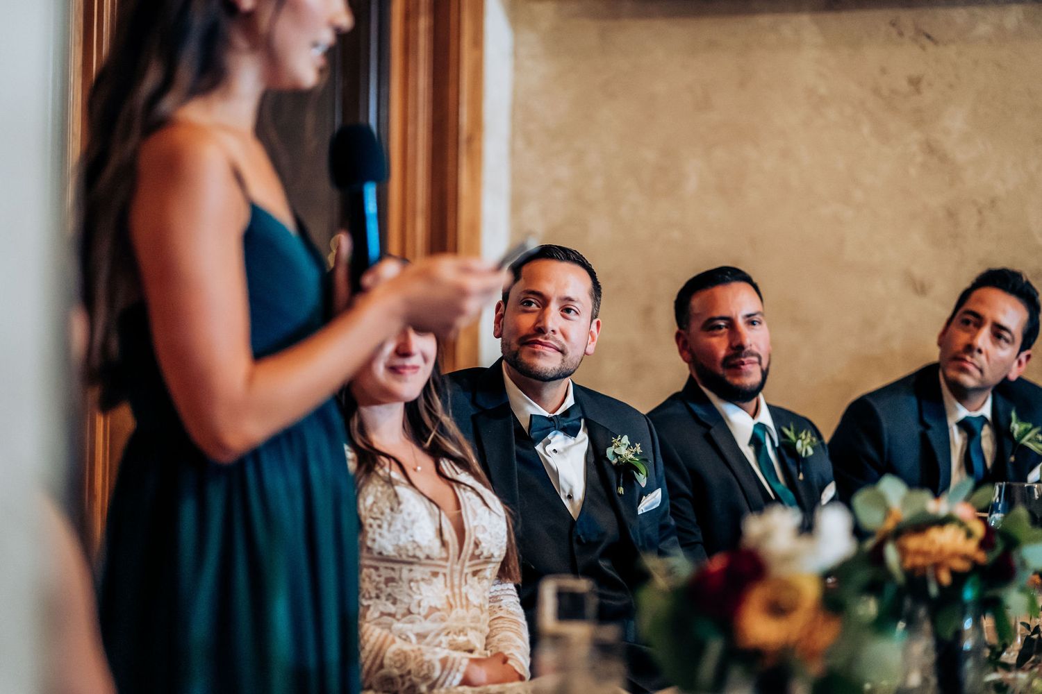 A wedding speech being delivered at an elegant reception with formal decor and lighting.