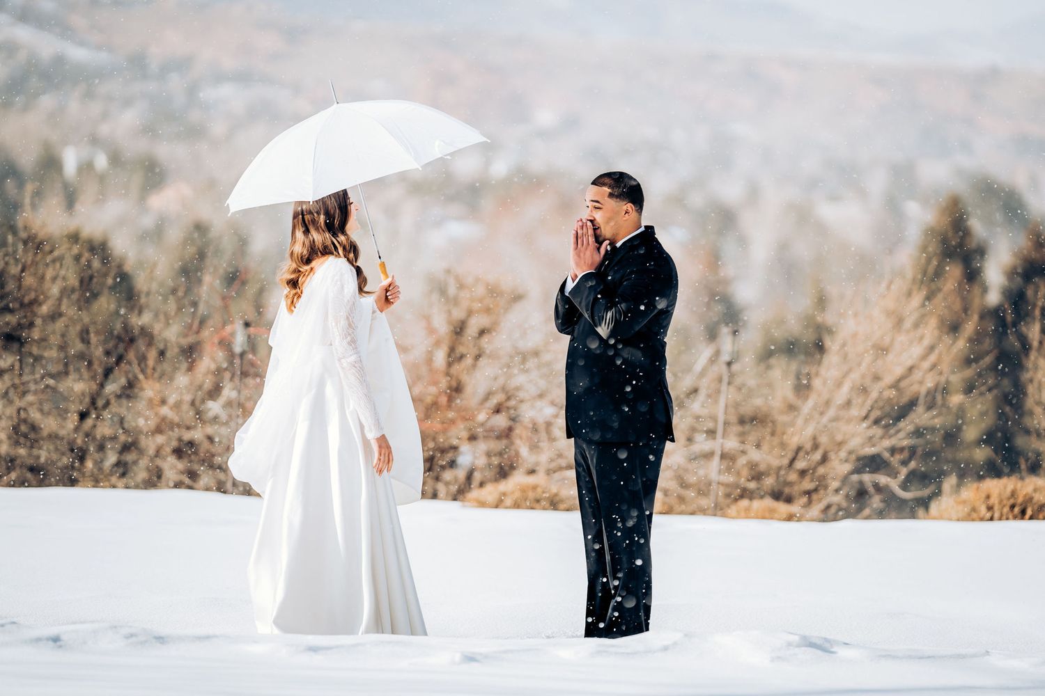 Two people having an emotional moment during their winter wedding photoshoot in the snow.