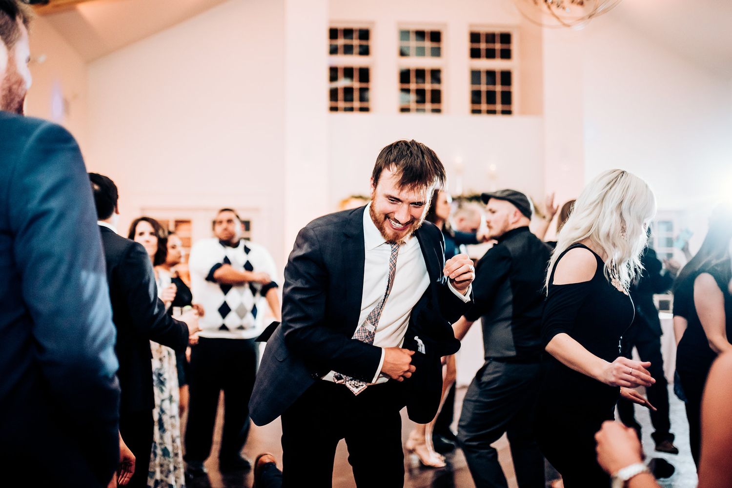 Guests bust out energetic dance moves during a wedding party reception.
