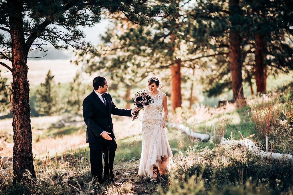 A couple shares an intimate moment in a pine forest during their wedding photoshoot.