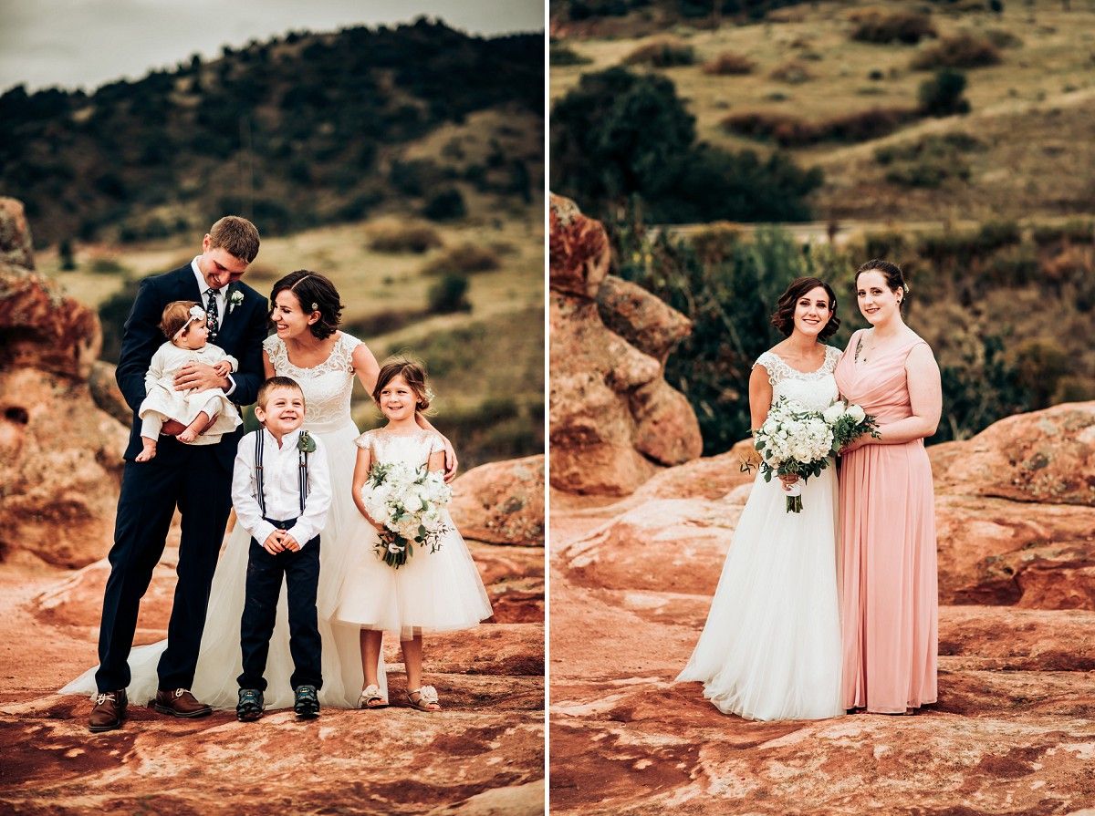 Wedding party poses on red rocks against mountain landscape backdrop.