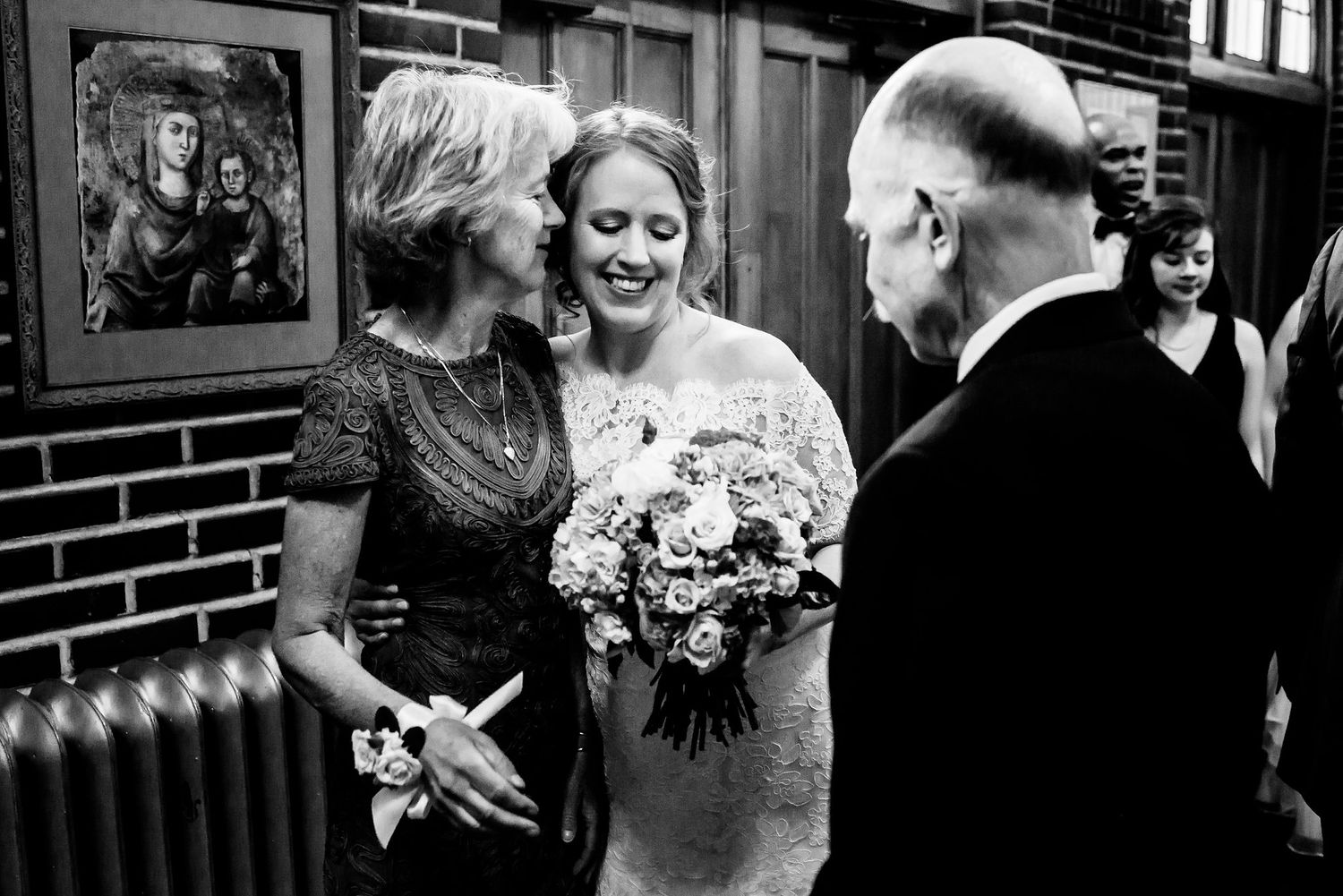 A black and white wedding photo capturing an intimate moment in a vintage-style interior.