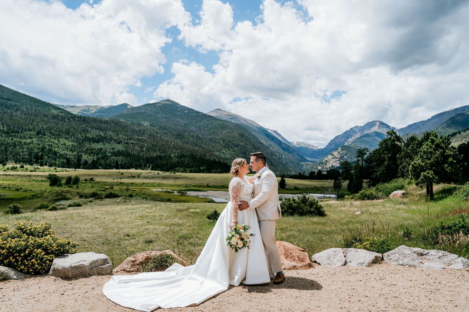 Wedding portrait with majestic Rocky Mountain landscape and cloudy blue skies in the background.