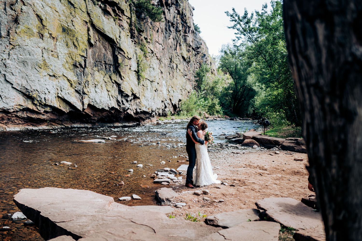 Wedding photography in scenic river gorge with dramatic rock walls and flowing water.